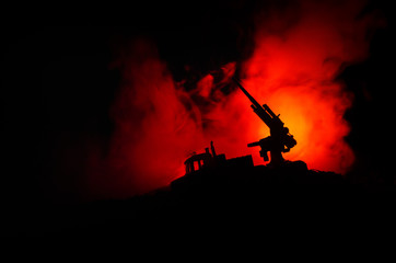 Fototapeta na wymiar An anti-aircraft cannon and Military silhouettes fighting scene on war fog sky background, World War Soldiers Silhouettes Below Cloudy Skyline at sunset. Attack scene.