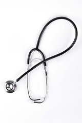 Fototapeta na wymiar Black medical stethoscope, top view. Medical equipment for heartbeat examination, white background.
