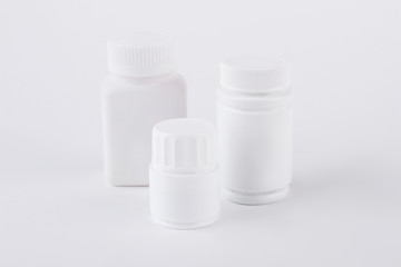 Three different sizes pills bottles. Set of white empty plastic containers for medicine or vitamins.
