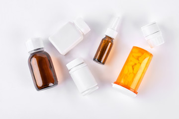 Bottles with medicine, top view. Set of vial bottles and pills on white background. Medicine, health care and pharmaceutical drugs concept.