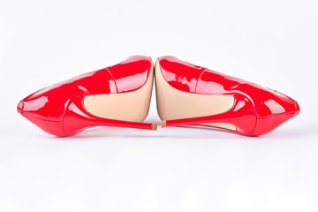 Woman beautiful red high heels. New classic shoes of red color with high heels on white background. Female elegance and sensuality.
