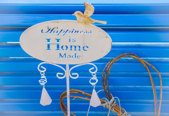 Decoration nameplate on blue bench with the title "Happiness is Home Made" designed for courtyard