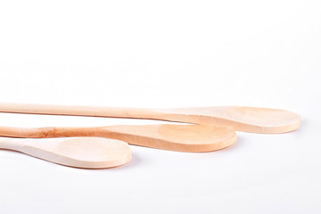 Three wooden spoons on white background. Set of traditional wooden spoons over white background. Natural kitchen utensils.