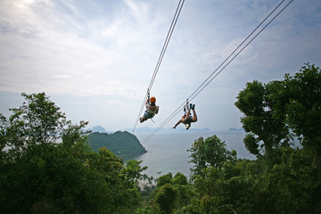 Ziplining on a zip wire connecting Las Cabanas beach in El Nido and Depeldet Island, on Palawan,...