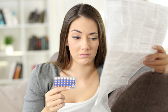 Suspicious woman reading a leaflet after taking contraceptive pills