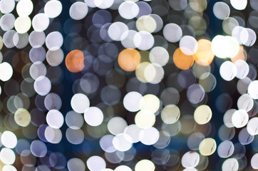 Bokeh light from the garlands on the window. Blurred abstract background.