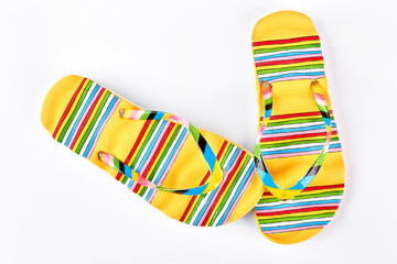 Female yellow patterned flip flops. Woman beautiful flip flops for vacation on white background, top view.