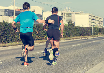 Running budy helping a friend compete in a marathon race.