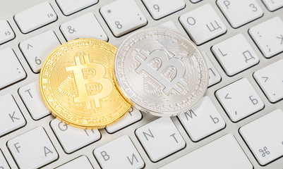 Coins of cryptocurrency lying over computer keyboard