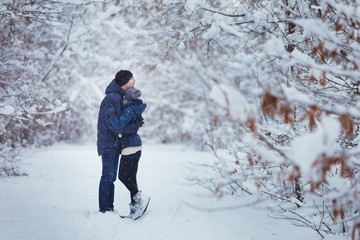 Fototapeta na wymiar Happy Couple embracing Outdoors in Snow Park. Winter Vacation. Blurred image