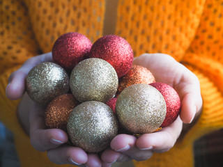 Christmas decorations shiny balls in a female hands.
