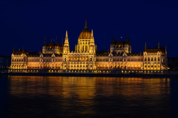 Panoramic view of Hungarian Parliament reflecting in Danube river. Night cityscape of Budapest