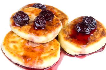 Delicious cheese pancakes with cherry jam on a white background, isolated