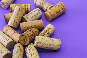 A random selection of used wine corks on violet background