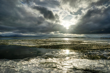 Winter Landscape frozen lake with ice floes and cloudy sky in Ic