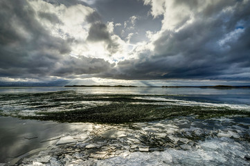 Winter Landscape frozen lake with ice floes and cloudy sky in Ic