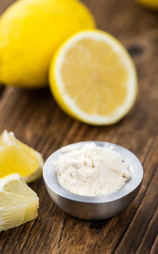 Portion of healthy Lemon powder on an old wooden table (selective focus; close-up shot)