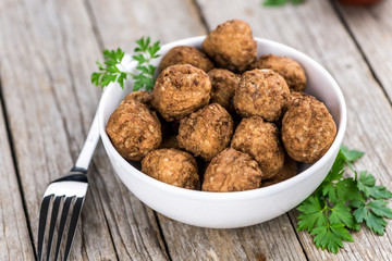 Vintage wooden table with Meatballs (selective focus; close-up shot)