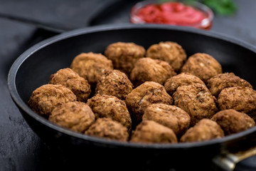 Fresh made Meatballs on a slate slab (close-up shot; selective focus)