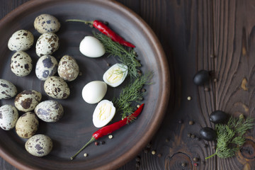 quail eggs, olives, chili and spices on a wooden table