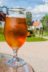 Glass of a beer on a table in a village.