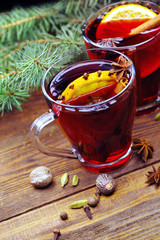 Glass cups of delicious Christmas mulled wine on wooden background, closeup