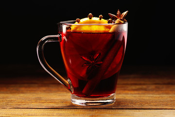 Glass cups of delicious Christmas mulled wine on wooden background, closeup
