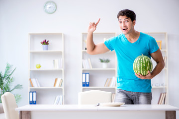 Man eating watermelon at home