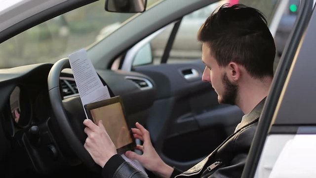 Young bearded freelancer working in the car. online earnings