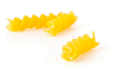 Closeup of raw, uncooked, dry fusilli or rotini pasta noodles with selective focus