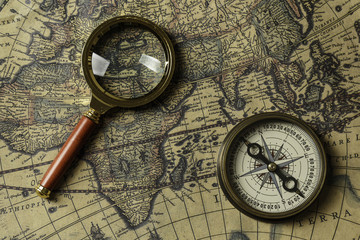 Fototapeta na wymiar Retro compass with old map and magnifier