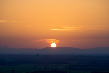 Sunset sky and big sun with mountain.