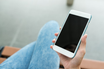 Woman holding cellphone with blank screen