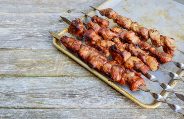 Shish kebab on skewers with onions. On the wooden table.
