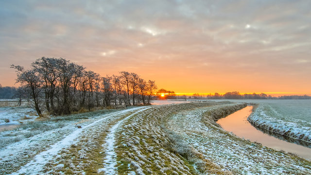 Dike near Meandering River in Frozen grassland landscape