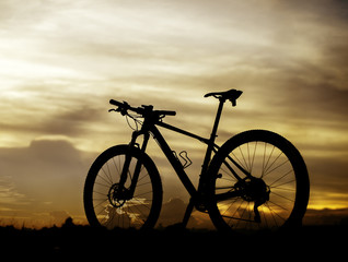 Silhouette bicycle on sunset background.