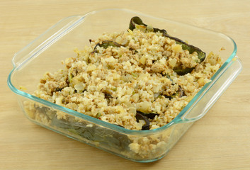 Preparation of chiles rellenos layered casserole with poblano peppers and turkey meat in glass baking dish