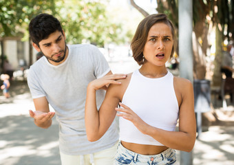 portrait of male and female talking emotional at the street