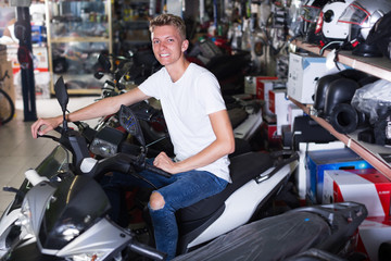 Fototapeta na wymiar Portrait of smiling young man sitting on the motorbike