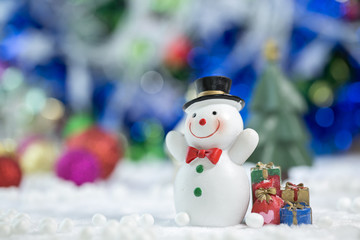 Snowman Standing with Gift Box on bokeh background. Christman Concept.