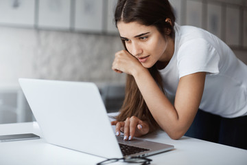 Close up of young woman using a laptop computer to apply for a job online.