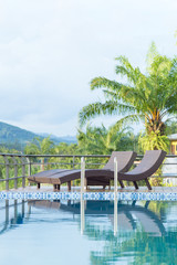 Swimming pool and chairs in front of the hotel.