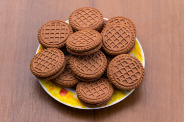 Chocolate cookies with cream filling on wooden table