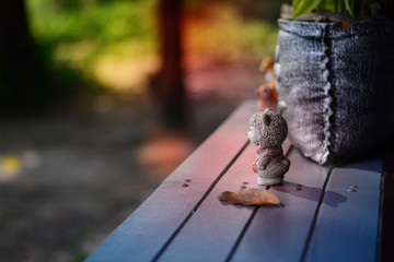 old white sheep doll on top of table with dry leaves