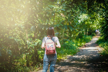 hipster woman traveler with backpack holding map at nature backgrounds park garden yard outdoors