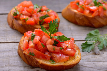 Bruschetta with tomatoes on wooden table