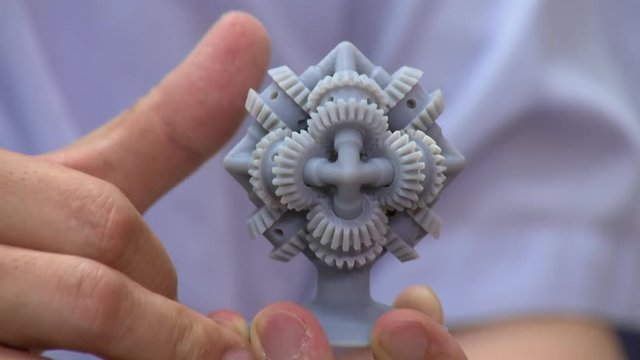 A man is using with his hands a brain gear machine printed with 3D technology.