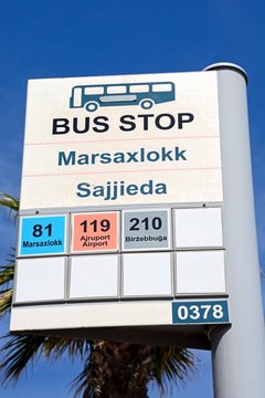 Bus stop sign showing destinations and bus numbers, Marsaxlokk, Malta.