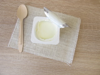 Joghurt im Plastikbecher mit Aluminiumdeckel
