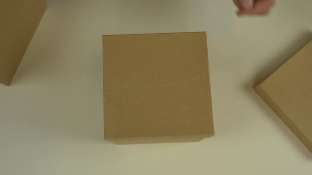 Time lapse top view. Hands of a man unpack gift boxes. The man takes the boxes one from the other. Many boxes of different sizes. The principle of nesting dolls. Gift unwrapping for the event.